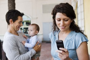 Parents with baby and mother with cell phone